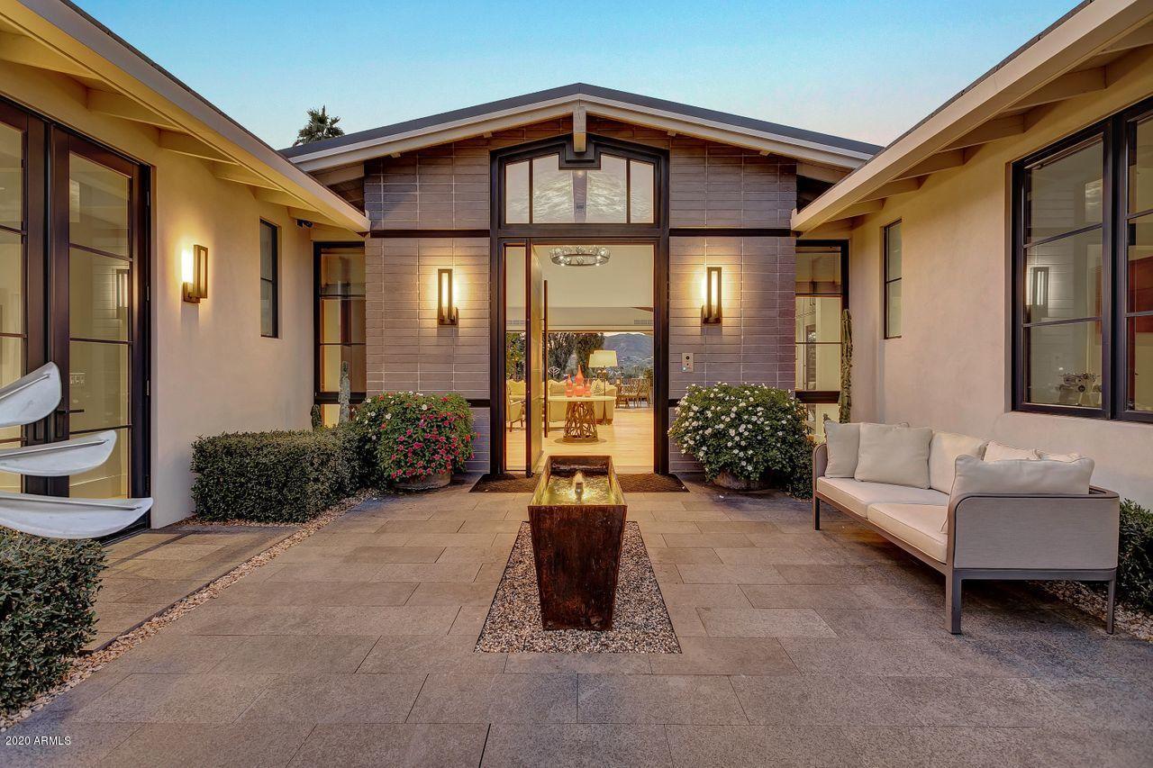 showcases a custom water feature & dramatic metal & wood pivot entry door.
