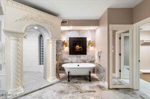 Primary suite bath with freestanding soaking tub and electric remote controlled fireplace