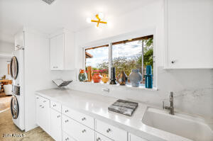 Laundry Room with Stackable Washer/Dryer and Sink
